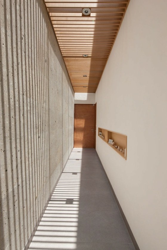 długi-wąski-korytarz-beton-ściana-i-biały-tynk
