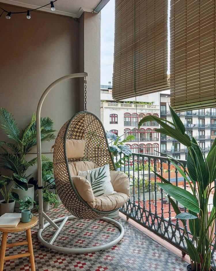 tropikalny balkon z dużymi roślinami i wiszącymi krzesłami