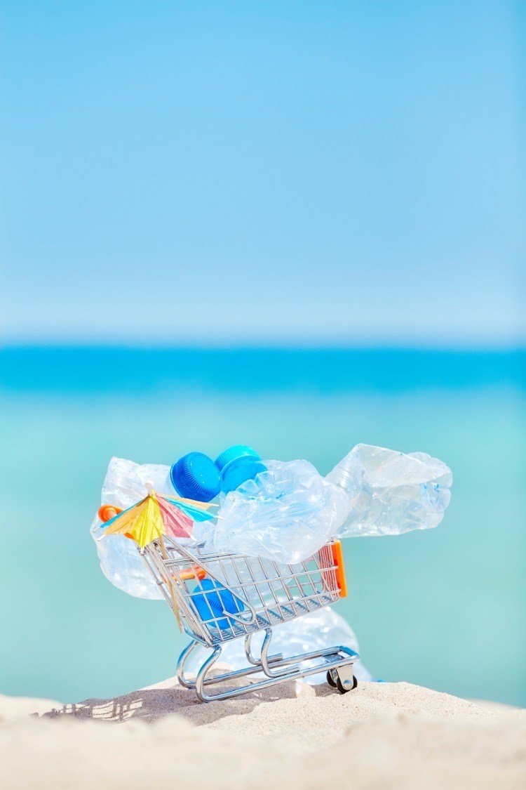 Symbolizuj koszyk z plastikowymi butelkami jako śmieci w morzu