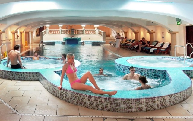 Fale zintegrowanej wanny z hydromasażem prowadzą do basenu basen-i-jaccuzi-z-kilkoma-osobami