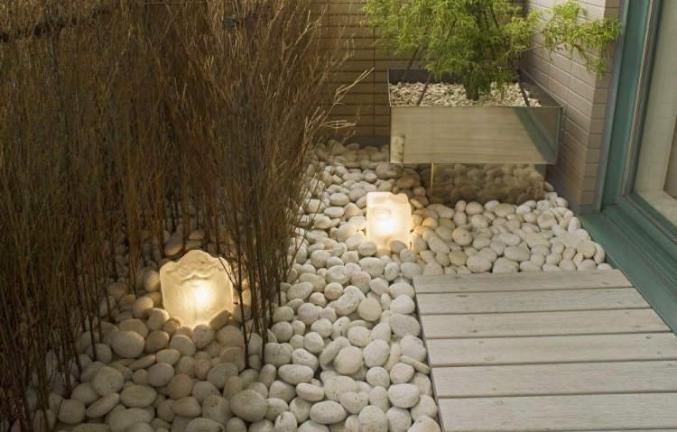 białe ozdobne kamienie rzeczne na podłodze i ozdobne światła Feng Shui projekt ogrodu białe-rzeka-kamienie-metal-donice-lampy podłogowe