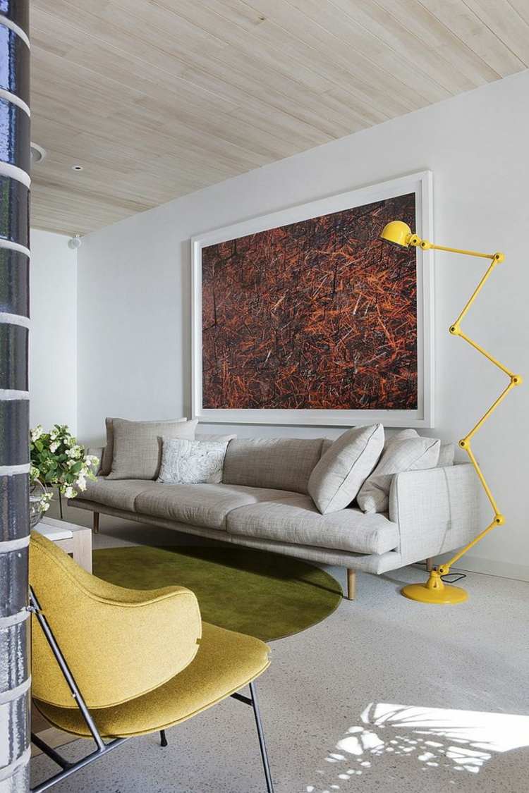 Żółta lampa podłogowa i szara sofa szaro-żółty w salonie nowoczesna-lampa podłogowa-ścienna-dekoracja