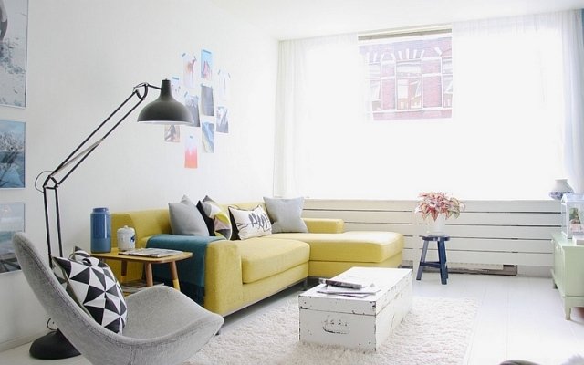 jasne kolory salon żółta sofa narożna szary fotel relaksacyjny biały kolor ściany jasne kolory-salon-żółty-narożnik-szara-fotel-relaks-mądry-kolor-ściany