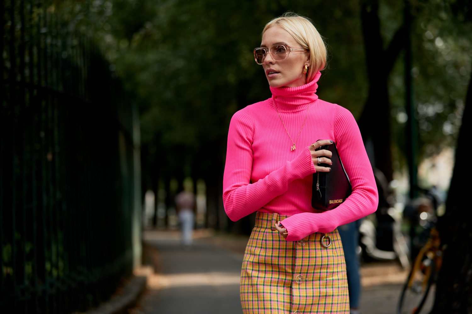 Neon trend sweter z golfem neonowa różowa skórzana torebka Balenciaga blond włosy mini spódniczka
